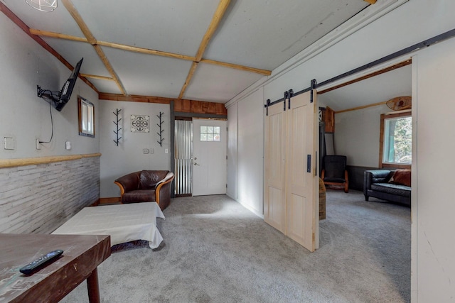 foyer with light carpet, a wealth of natural light, and a barn door