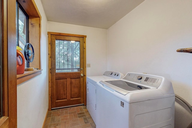 laundry room featuring washing machine and clothes dryer and plenty of natural light