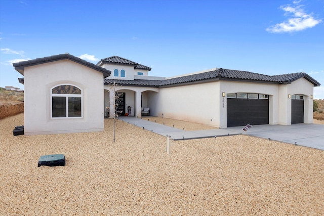 mediterranean / spanish-style home with a garage