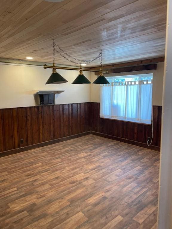 empty room with wood walls, wood-type flooring, and wooden ceiling