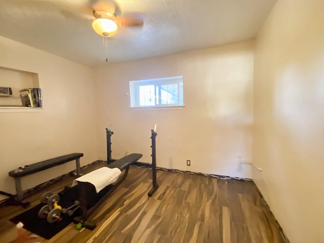 exercise room featuring ceiling fan and dark hardwood / wood-style floors