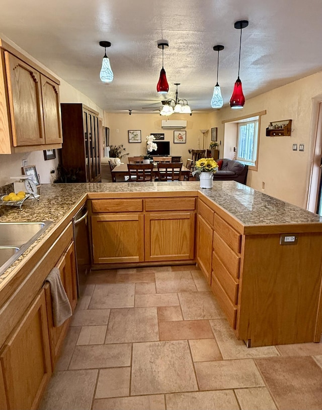 kitchen with kitchen peninsula, ceiling fan, hanging light fixtures, a textured ceiling, and stainless steel dishwasher