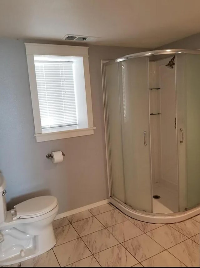 bathroom featuring walk in shower and toilet