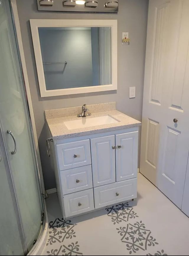 bathroom featuring tile patterned flooring, a shower with door, and vanity