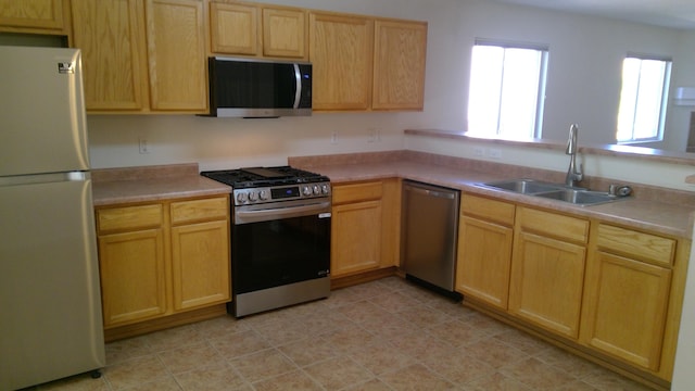 kitchen featuring light brown cabinetry, appliances with stainless steel finishes, and sink