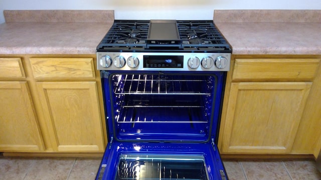 kitchen with stainless steel range and light tile patterned flooring