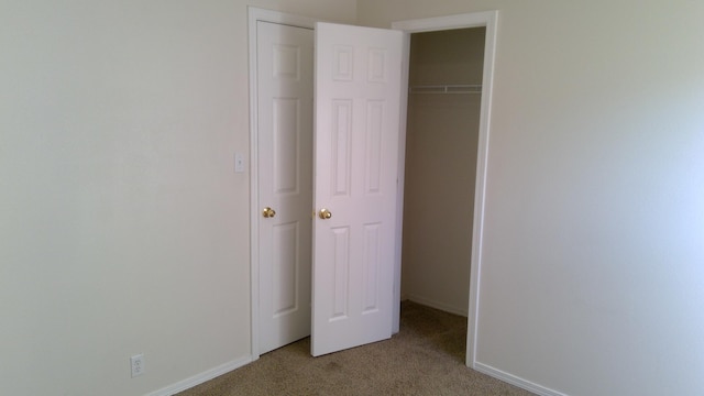 unfurnished bedroom with light carpet and a closet