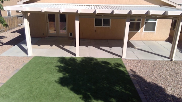 rear view of property featuring a yard, french doors, and a patio area