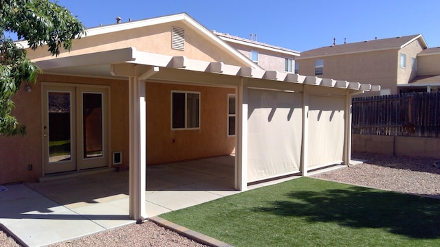 rear view of house featuring a patio and a lawn