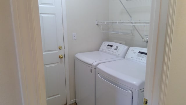 clothes washing area with separate washer and dryer