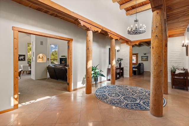 hallway with a notable chandelier, beam ceiling, light tile patterned floors, wooden ceiling, and ornate columns