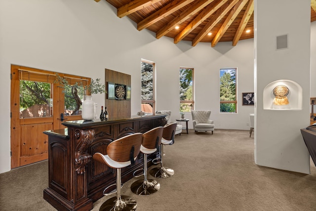 bar featuring carpet floors, beamed ceiling, high vaulted ceiling, and wooden ceiling