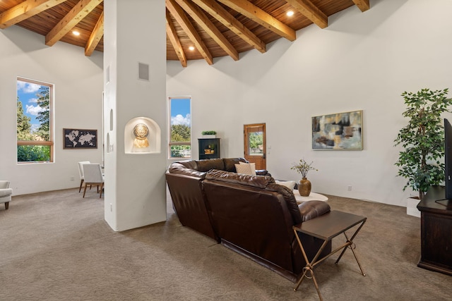 carpeted living room featuring wood ceiling, a wealth of natural light, beam ceiling, and high vaulted ceiling