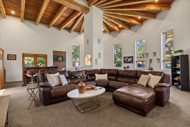 living room with beamed ceiling, wood ceiling, a towering ceiling, and carpet