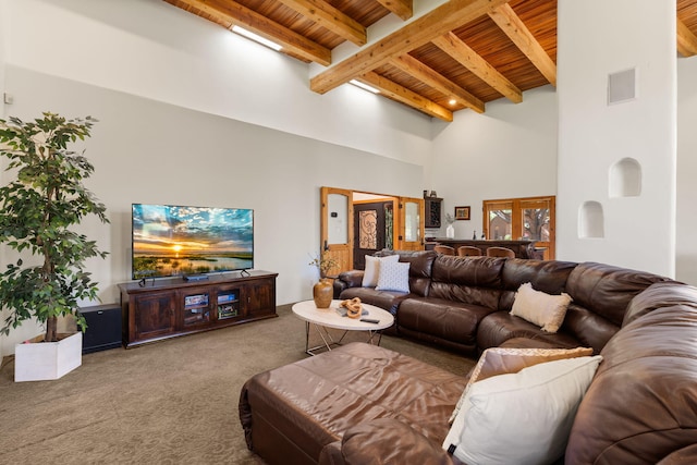 carpeted living room with a towering ceiling, beam ceiling, and wooden ceiling