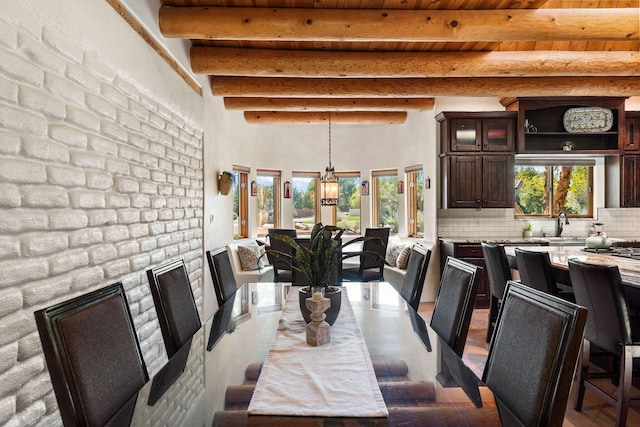 dining room with sink, plenty of natural light, beam ceiling, and wooden ceiling