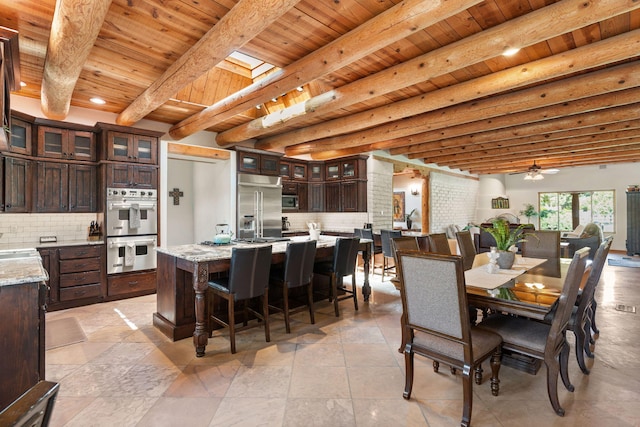 dining space featuring wood ceiling, beam ceiling, ceiling fan, and sink