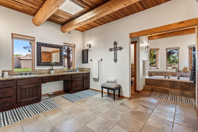 bathroom featuring wood ceiling, a washtub, beam ceiling, vanity, and toilet