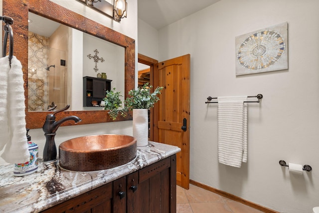 bathroom with tiled shower, vanity, and tile patterned floors