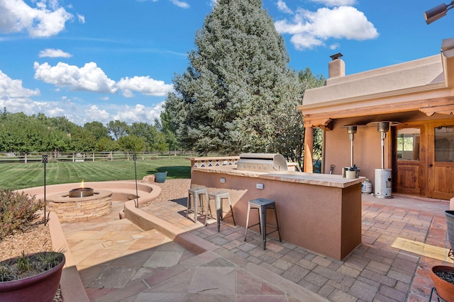 view of patio / terrace with area for grilling, an outdoor bar, and exterior kitchen