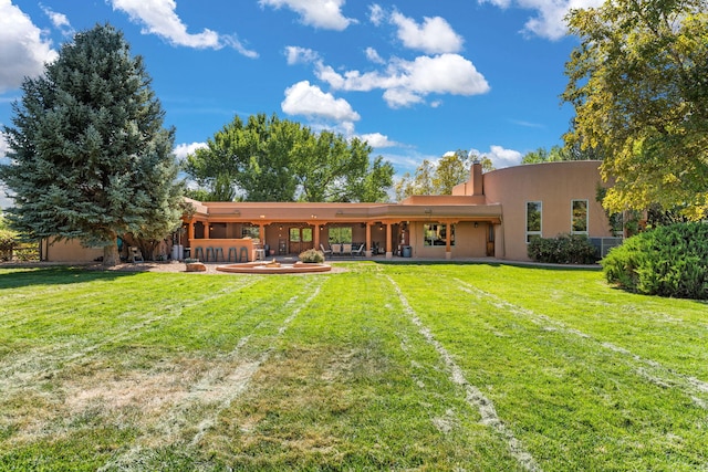 rear view of property with a patio area and a yard