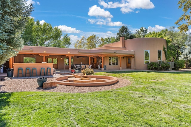 rear view of house featuring a yard and a patio area