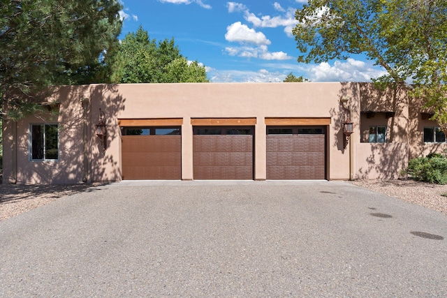 pueblo revival-style home featuring a garage