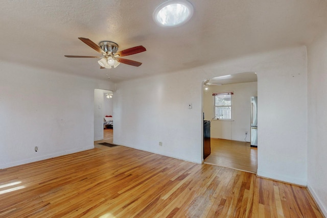 unfurnished room featuring light hardwood / wood-style flooring, ceiling fan, and a textured ceiling