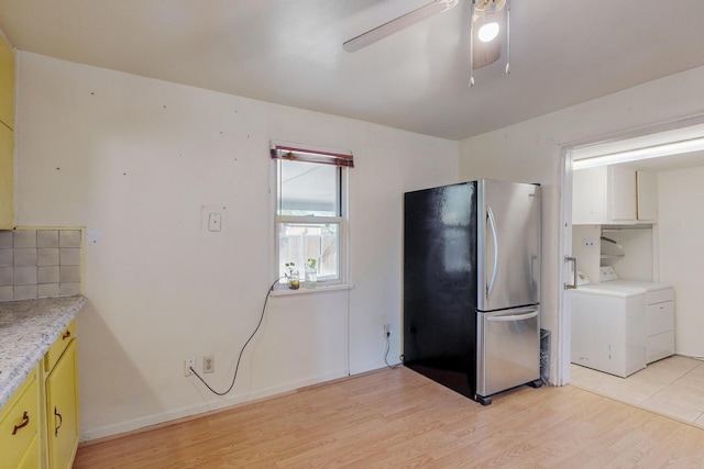 kitchen with light wood-type flooring, washer / clothes dryer, ceiling fan, and stainless steel refrigerator