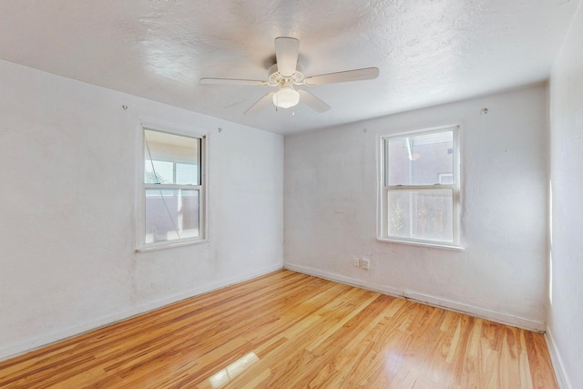 empty room featuring ceiling fan, a textured ceiling, and light wood-type flooring