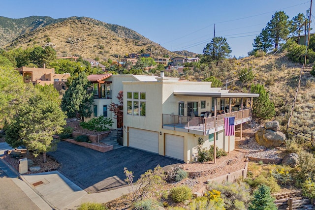 view of front facade with a mountain view, a garage, and a balcony