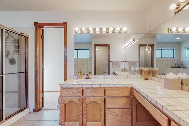 bathroom with tile patterned floors, a shower with door, and vanity