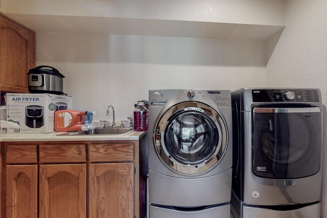 laundry room featuring cabinets, sink, and washer and clothes dryer