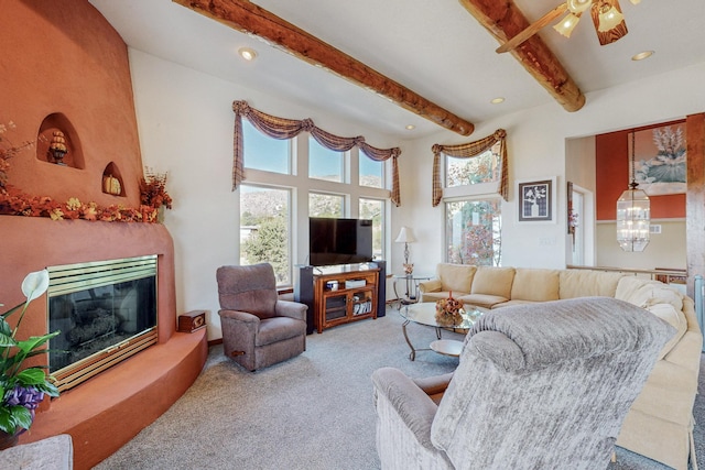 living room with beamed ceiling, light colored carpet, ceiling fan, and a towering ceiling