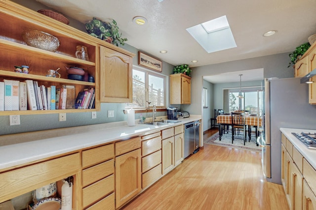 kitchen featuring sink, dishwasher, a skylight, decorative light fixtures, and light brown cabinets