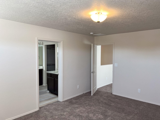 carpeted spare room featuring a textured ceiling