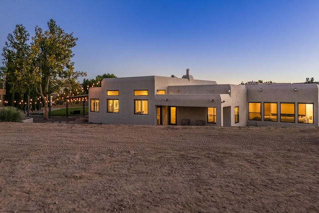 back of property at dusk with stucco siding