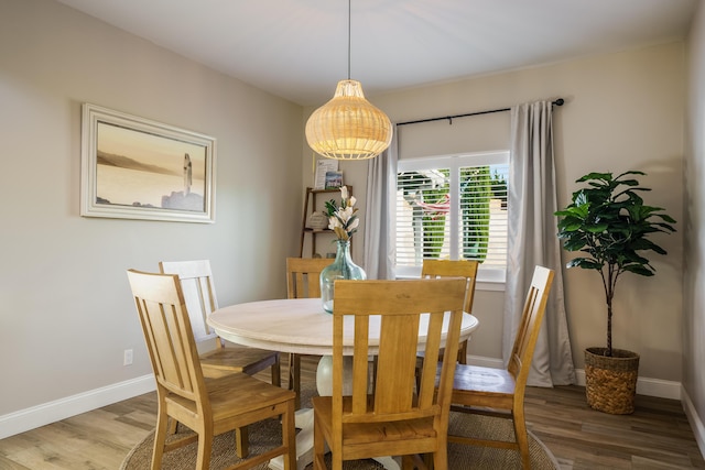 dining space with baseboards and wood finished floors