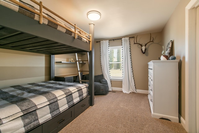 bedroom with baseboards and light colored carpet