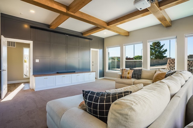 living room featuring baseboards, beamed ceiling, and light colored carpet