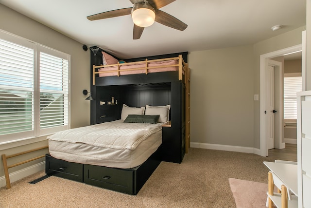 bedroom with light carpet, visible vents, a ceiling fan, and baseboards