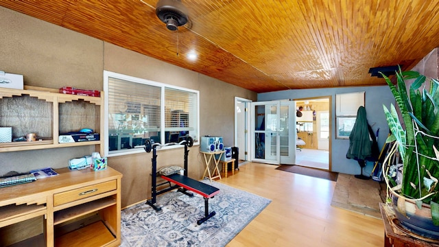 exercise room with french doors, light wood-type flooring, vaulted ceiling, and wooden ceiling