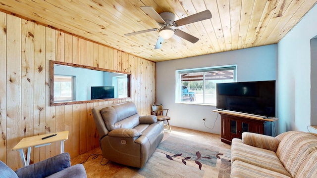 carpeted living room featuring wood ceiling, wood walls, and ceiling fan