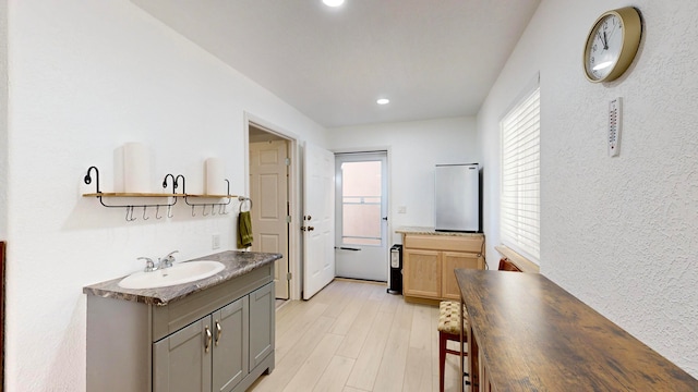 interior space with light hardwood / wood-style flooring, gray cabinetry, and sink