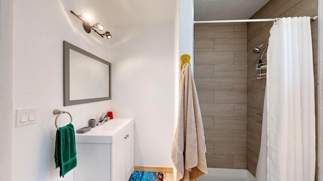 bathroom featuring walk in shower and vanity