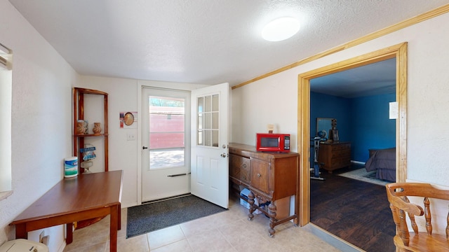 entrance foyer with a textured ceiling and light tile patterned floors