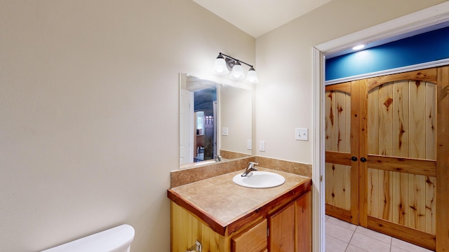 bathroom featuring tile patterned flooring, vanity, and toilet