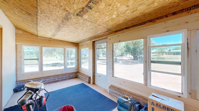 unfurnished sunroom featuring vaulted ceiling