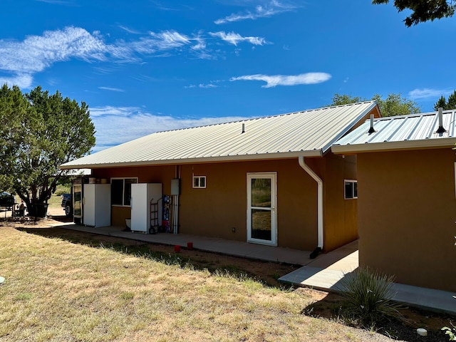 rear view of property with a yard and a patio area