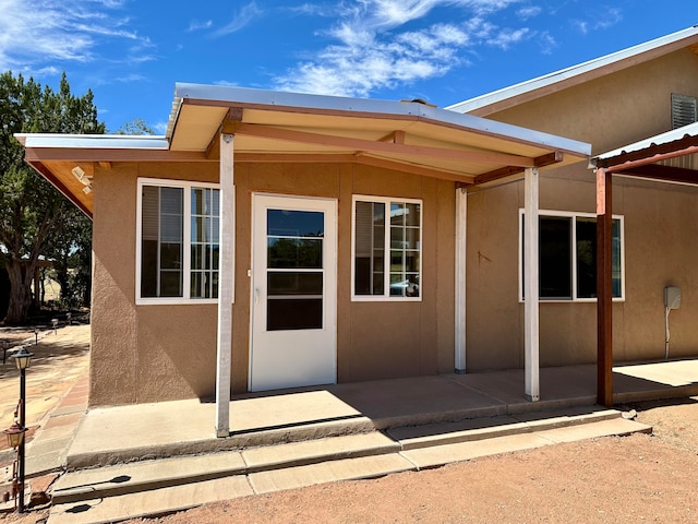 view of exterior entry with a patio